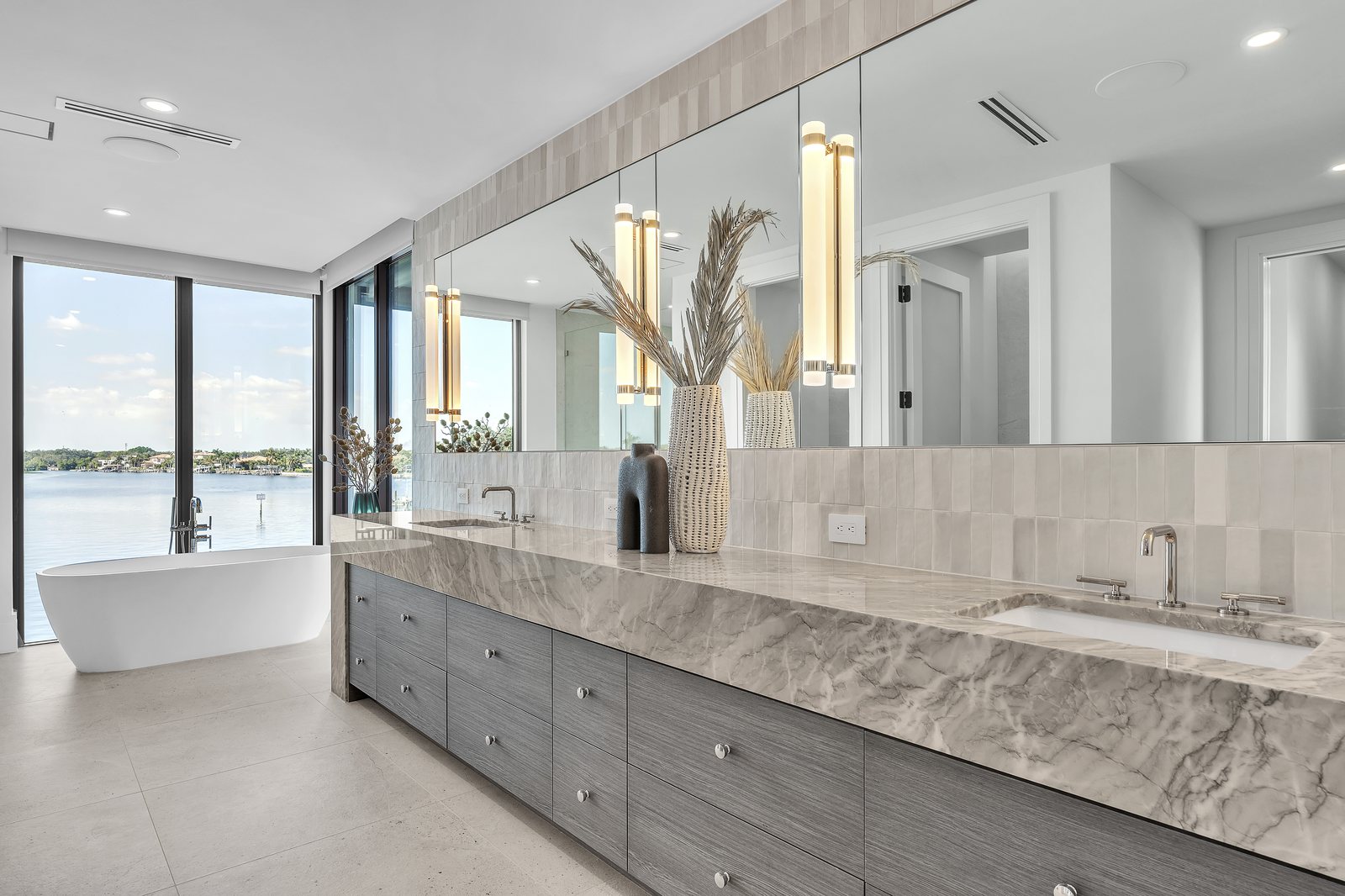 Waterfront double vanity with marble counters and freestanding tub