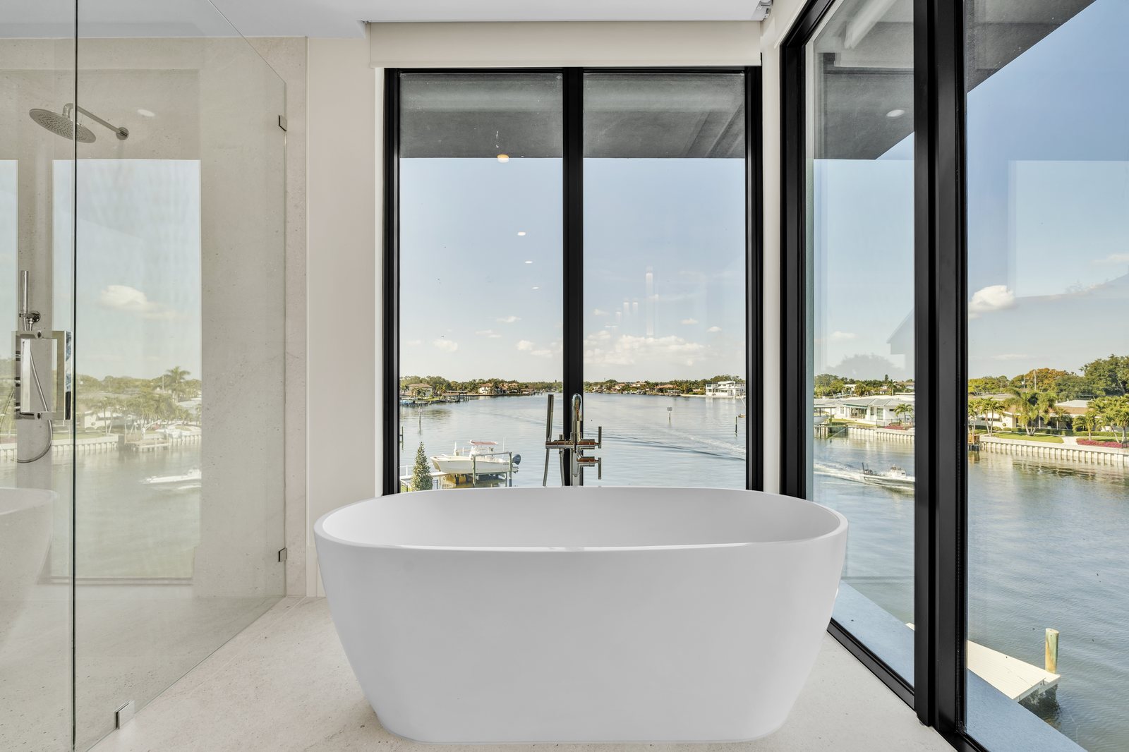 Freestanding soaking tub with floor-to-ceiling waterfront view